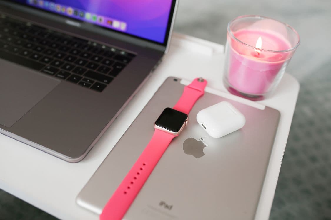 Neatly arranged desk with a laptop, tablet, smartwatch, and AirPods. Photo by Melike B on Pexels